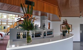 a modern bar with white marble countertops and wooden paneling , featuring a variety of bottles and vases at Lyndoch Hill