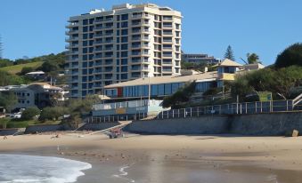 a beachfront hotel with a modern design and large windows , situated on the sandy shore at Coolum Caprice