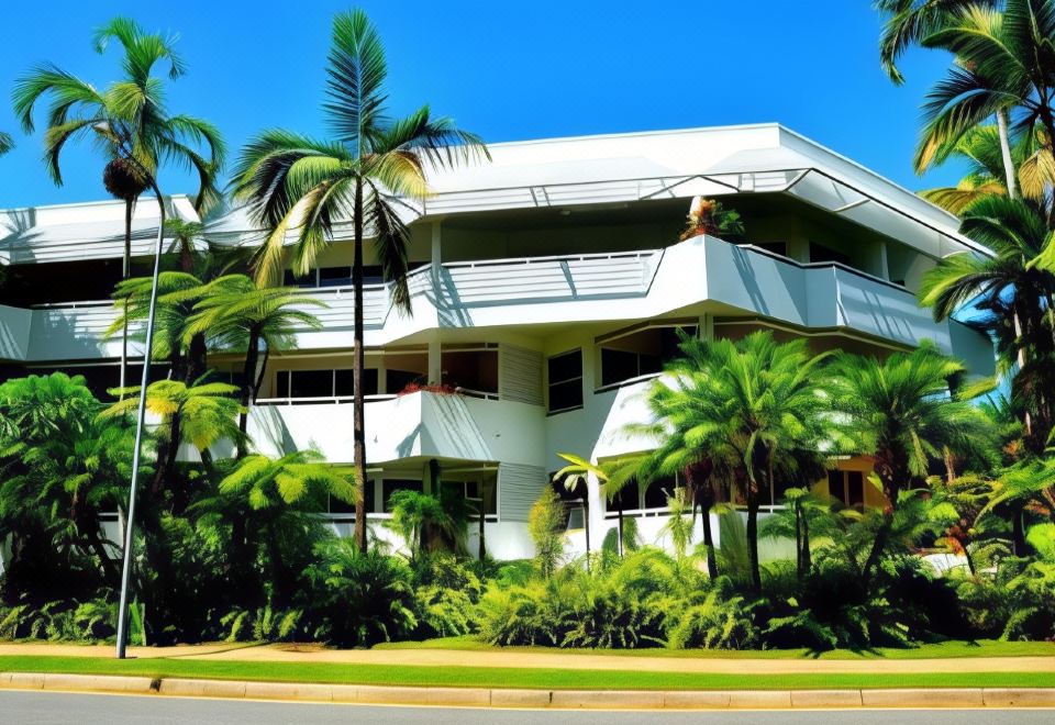 a white building surrounded by palm trees and other vegetation , located in a tropical setting at Marina Terraces Port Douglas