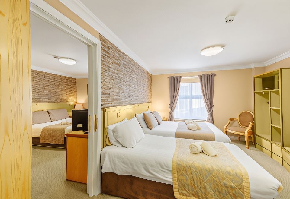 a hotel room with two beds , one on the left and one on the right side of the room at Kilmorey Arms Hotel
