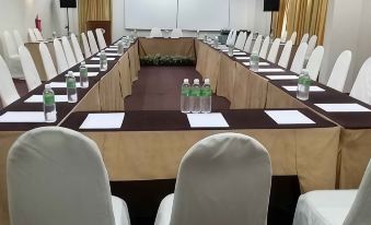 a conference room set up for a meeting , with rows of chairs arranged in a semicircle at Garden View Hotel