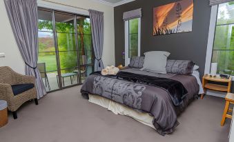 a large bed with a gray and black patterned blanket is in a room with sliding glass doors at The Summit Lodge