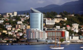 a large building with a sail is situated on the shore of a body of water at Simon Hotel