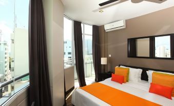 a hotel room with a double bed and a double bed , both covered in orange sheets at The Beehive