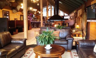 a spacious living room with multiple couches , chairs , and a coffee table , as well as a kitchen area with a dining table at Shasta Inn