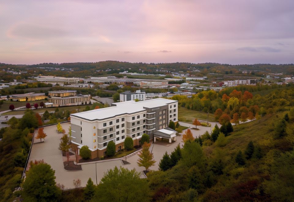 a large hotel complex with multiple buildings and trees , set against the backdrop of a city at Courtyard Pittsburgh Washington/Meadow Lands