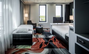 a hotel room with two beds , one on the left side and the other on the right side of the room at Fletcher Wellness-Hotel Leiden
