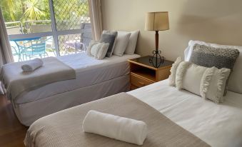a hotel room with two beds , one on the left side and another on the right side at Marina Terraces Port Douglas