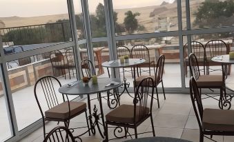 an outdoor dining area with tables and chairs , as well as a view of the desert at Pyramids View Inn