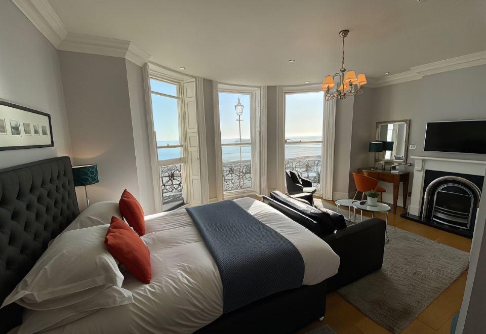 a large bed with a blue and white blanket is in a room with two windows at A Room with A View