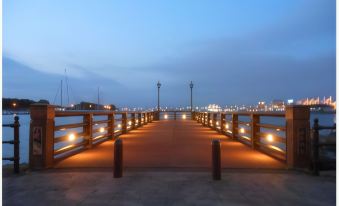 a wooden pier with lanterns on either side , providing a serene and picturesque view of the ocean at Route Inn Grantia Hakodate Ekimae