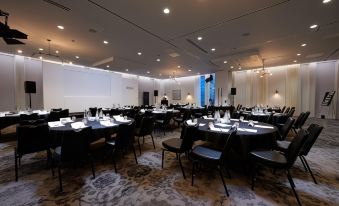 a large dining room with round tables and chairs set up for a formal event at Hotel Brooklyn Manchester