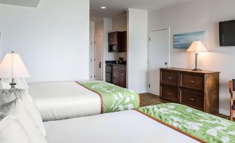a hotel room with two beds , one on the left side of the room and the other on the right side at Island Inn & Suites, Ascend Hotel Collection