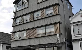 a modern building with multiple floors , including a balconies and other architectural features , situated in an urban setting at Yamadaya