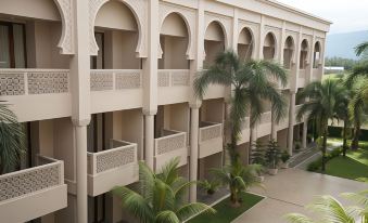 a modern , white building with arched balconies and a central courtyard filled with palm trees at The Pade Hotel