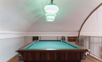a pool table with a green felt top and three white lights hanging from the ceiling at Hotel de Ville