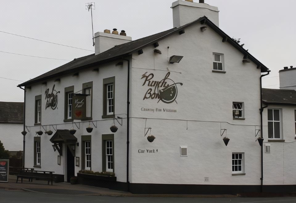 "a white building with a sign that reads "" punch bowl pub & restaurant "" on the side" at The Punchbowl Hotel