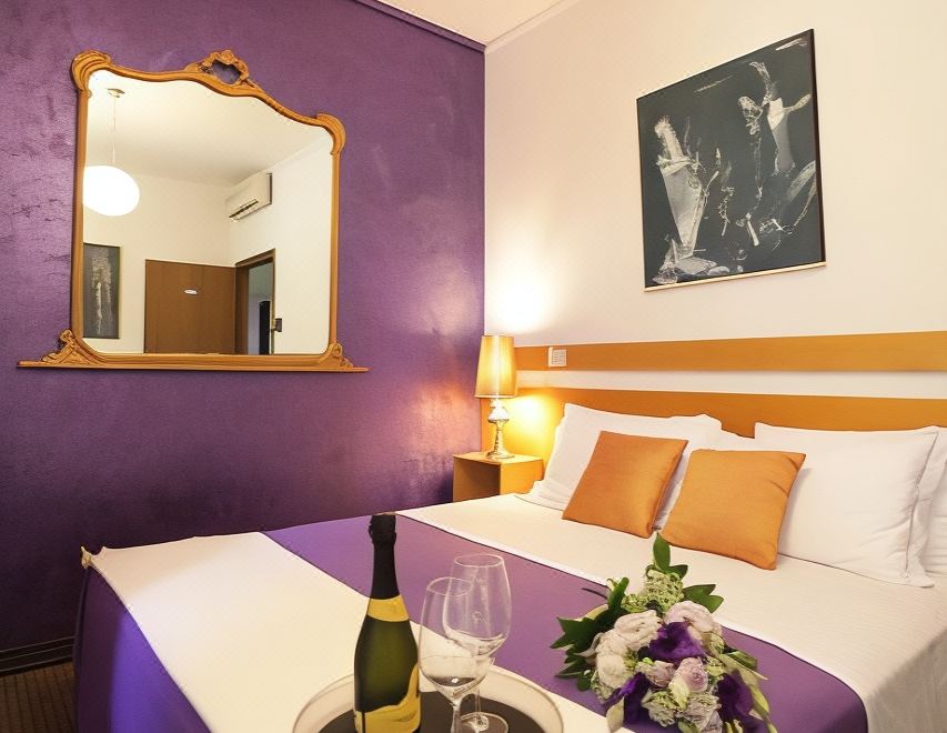 a bedroom with a purple and white color scheme , featuring a bed with a bottle of wine on the nightstand at Art Hotel