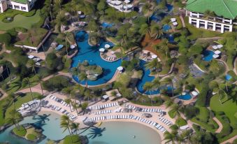 aerial view of a resort with multiple buildings and a large pool surrounded by palm trees at Grand Hyatt Kauai Resort and Spa