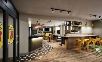 a modern restaurant with wooden floors , a bar area , and various seating options for customers at Super 8 by Wyndham Chester East