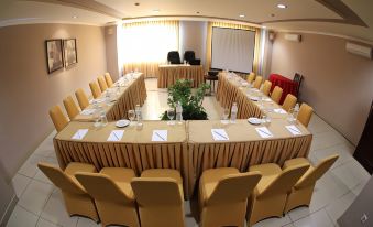 a large conference room with a long table set for a meeting , surrounded by chairs at Grand Zuri Dumai