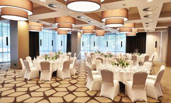 a large banquet hall with numerous tables and chairs set up for a formal event at Steigenberger Hotel Koln