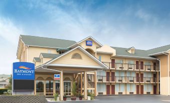 a large , modern hotel with multiple floors , wooden exterior , and an arched entrance , under a clear blue sky at St. James Hotel Selma, Tapestry Collection by Hilton