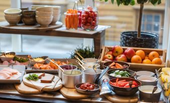 a table is filled with various food items , including fruits and vegetables , in bowls and on trays at Clarion Hotel Bergen