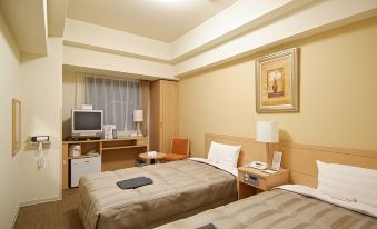 a hotel room with two beds , a desk , and a window , decorated in beige colors at Route Inn Grantia Hakodate Ekimae