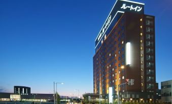 a large , modern hotel building with multiple floors and lights on at night , situated on a street corner at Route Inn Grantia Hakodate Ekimae