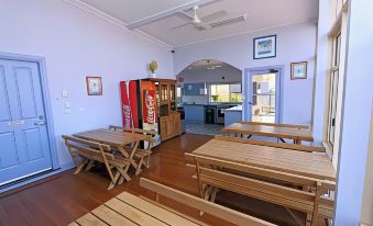a dining room with wooden tables and benches , along with a coca - cola vending machine in the background at Waterview Gosford Motor Inn