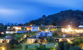 a modern house situated on top of a hill , surrounded by trees and lit up at night at Veravian Resort