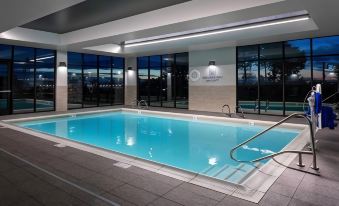 a large swimming pool with a ladder and sign on the wall , surrounded by buildings at Courtyard Pasco Tri-Cities Airport