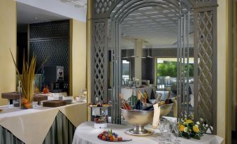 a table with a silver centerpiece and fruit is set up in front of a mirror at Grand Hotel Arenzano