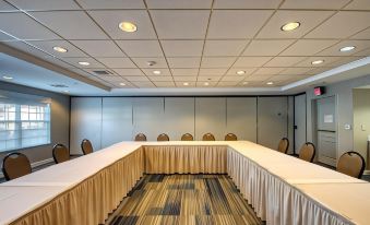 a conference room set up for a meeting , with several chairs arranged in rows and a table in the center at Hilton Garden Inn Oconomowoc