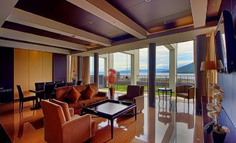 a spacious living room with a large flat - screen tv mounted on the wall , surrounded by couches and chairs at Sahid Bela Ternate