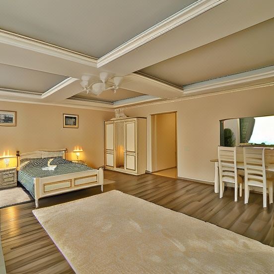 a spacious bedroom with hardwood floors , a large bed , and a tv mounted on the wall at Voyage