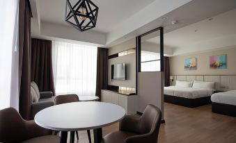 a modern living room with a white table and chairs , brown couch , and black pendant light at Higher Hotel
