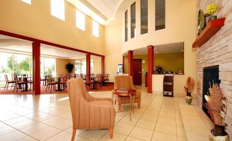 a spacious lobby with a fireplace , couches , and chairs arranged for a meeting or conversation at Comfort Inn & Suites Saratoga Springs