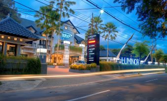 "a large building with a sign that says "" msp luminoir "" and palm trees in front of it" at Luminor Hotel Jember by WH