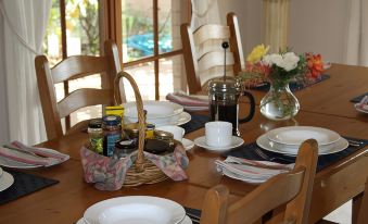 a dining room with a table set for breakfast , featuring a variety of plates , cups , and utensils at Strathearn Park Lodge