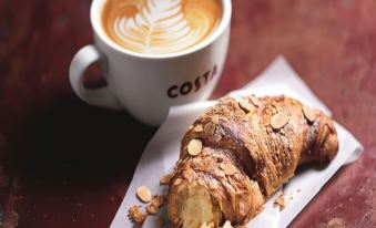 a croissant and a cup of coffee are placed on a table , creating a cozy atmosphere at Days Inn by Wyndham Sutton Scotney South