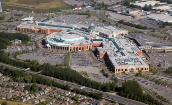 aerial view of a large shopping mall with various stores and parking lots , situated near a highway at The Ascott