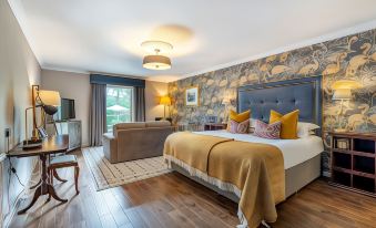 a large bed with a wooden headboard is in the center of a room with blue walls and hardwood floors at Banchory Lodge Hotel