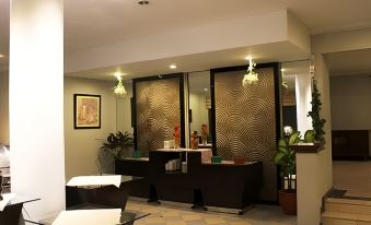 a modern hotel lobby with a check - in desk and a staircase leading to the second floor at Horison Tirta Sanita Spa Resort