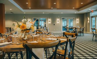 a dining room with a long wooden table set for a formal event , surrounded by chairs at Saranac Waterfront Lodge, Trademark Collection by Wyndham