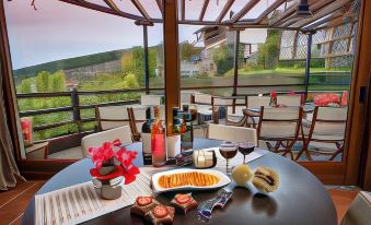 a table is set with wine glasses , a plate of food , and various utensils in an outdoor setting at Hotel Petradi