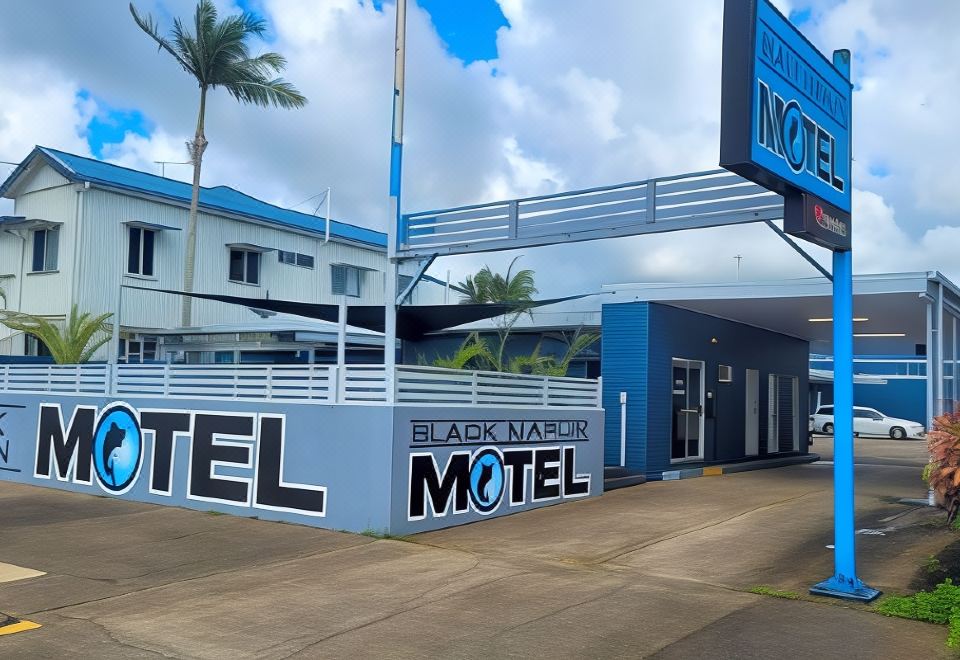 "a blue motel with a sign that reads "" black narcissus motel "" prominently displayed on the building" at Black Marlin Motel