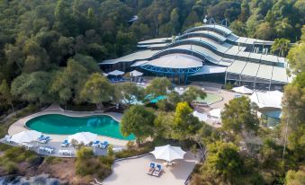 aerial view of a large resort with multiple swimming pools , lush greenery , and trees surrounding the site at Kingfisher Bay Resort