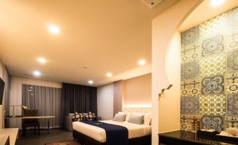a modern bedroom with a large bed , white walls , and blue bedding , along with a black desk and other furniture at Alfahad Hotel